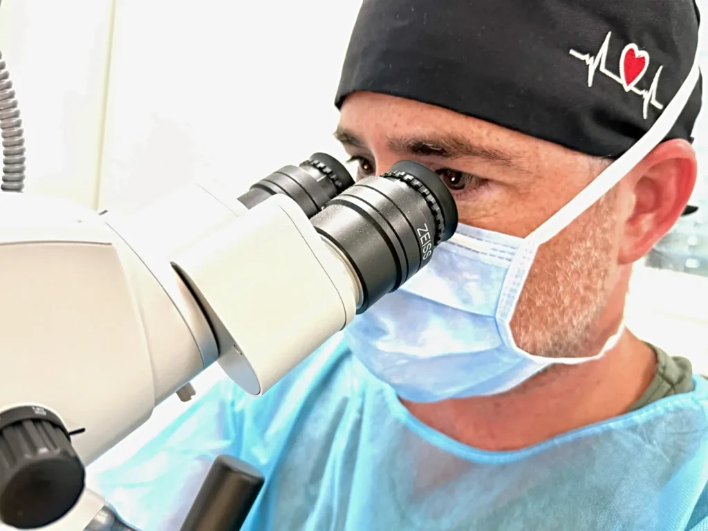 HNO-Chirurg am OP-Mikroskop während einer mikrochirurgischen Operation